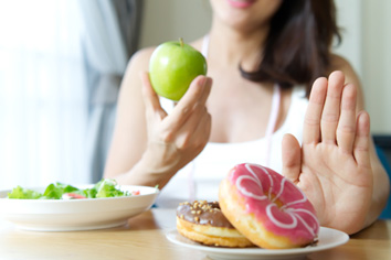a woman eating an apple instead of a donut