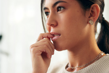 a woman nervously biting her fingernails