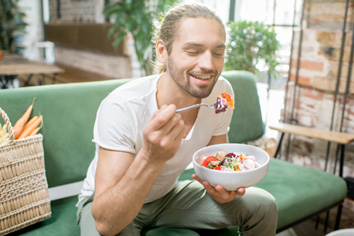 Man eating fruit out of a bowl