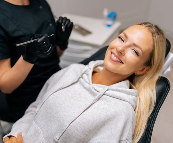 Happy dental patient reclining in treatment chair