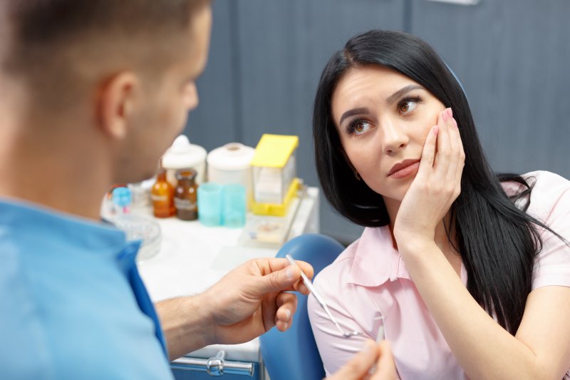 woman with dental emergency talking to dentist