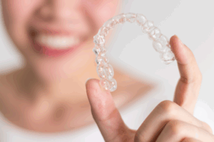 a close-up of a patient holding their Invisalign aligner