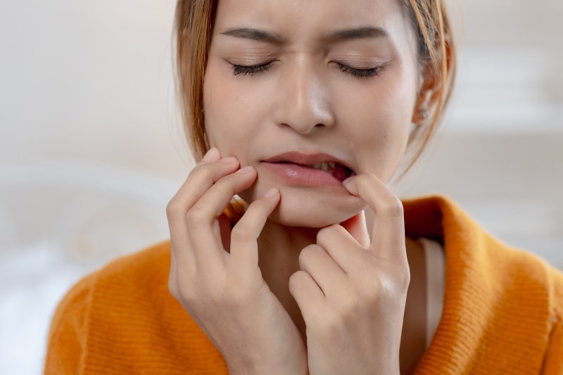 A pained woman experiencing irritated gums