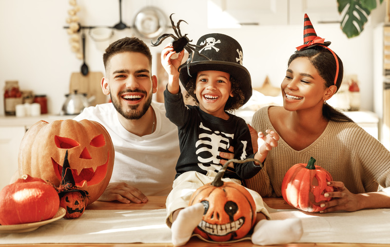 Child and parents with good oral health celebrating Halloween
